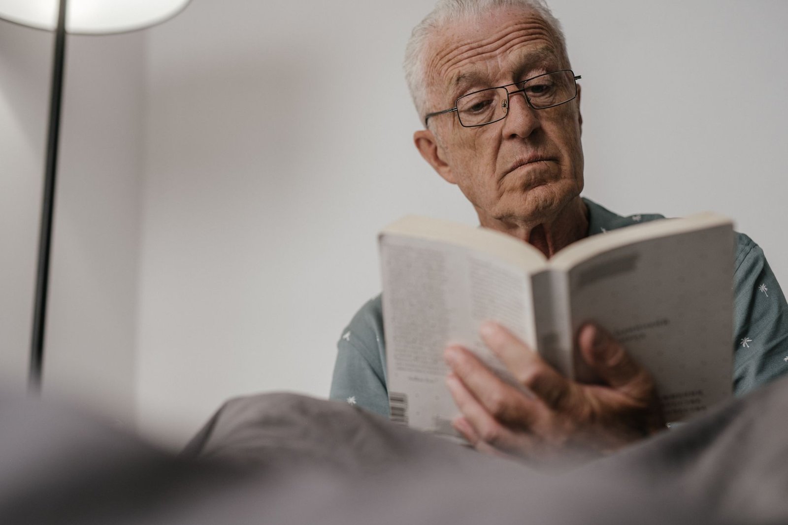 Augen im Alter – älterer Mann liest mit Brille ein Buch