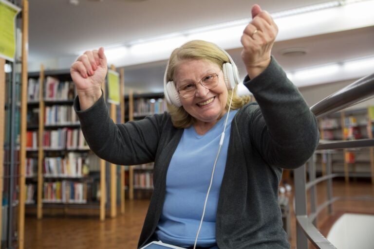Musik im Alter – fröhliche Seniorin tanzt mit Kopfhörern zur Musik