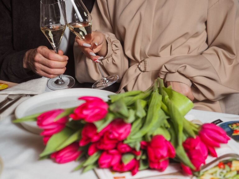 Ruhestand Glückwünsche und Zitate – Anstoßen mit Sekt über einem Tulpenstrauß
